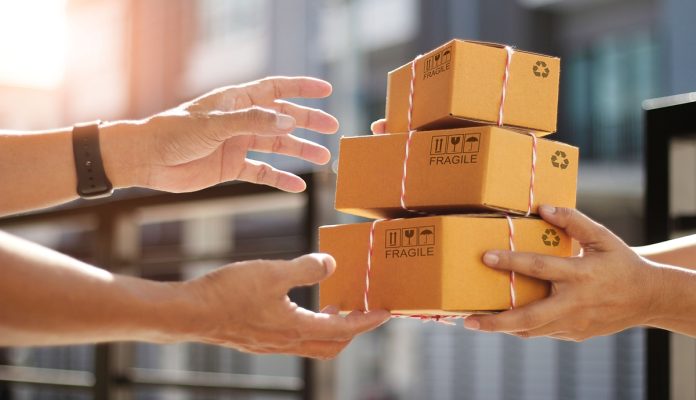 Hands of customer receiving a cardboard boxes parcel from delivery man in the morning, delivery service concept